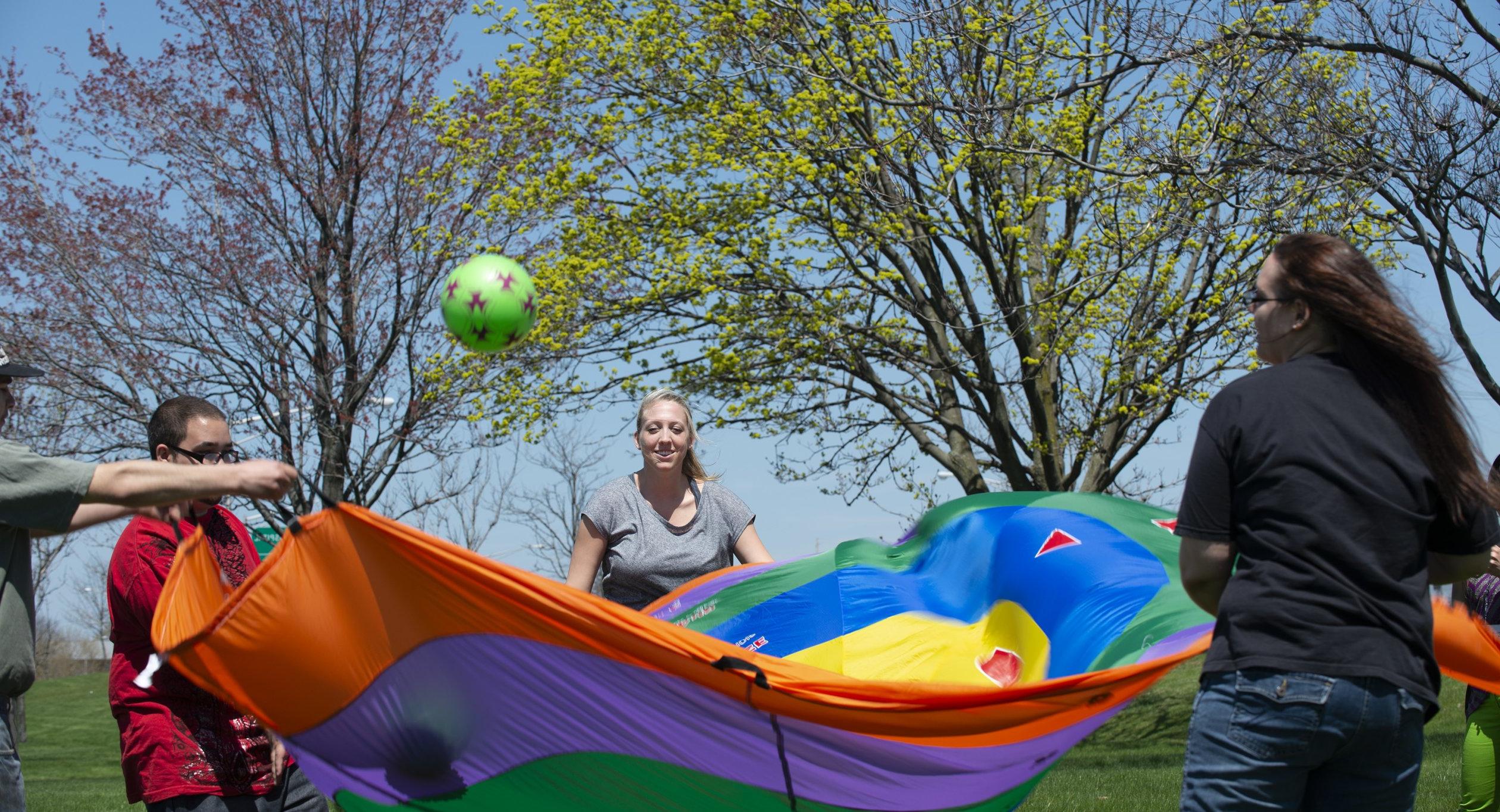 Occupational Therapy students at work with parachute and ball.